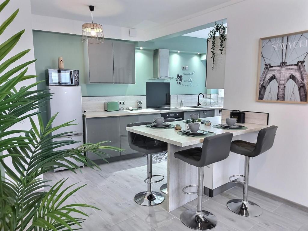 a kitchen with a table and two bar stools at La villageoise in Dammartin-en-Goële