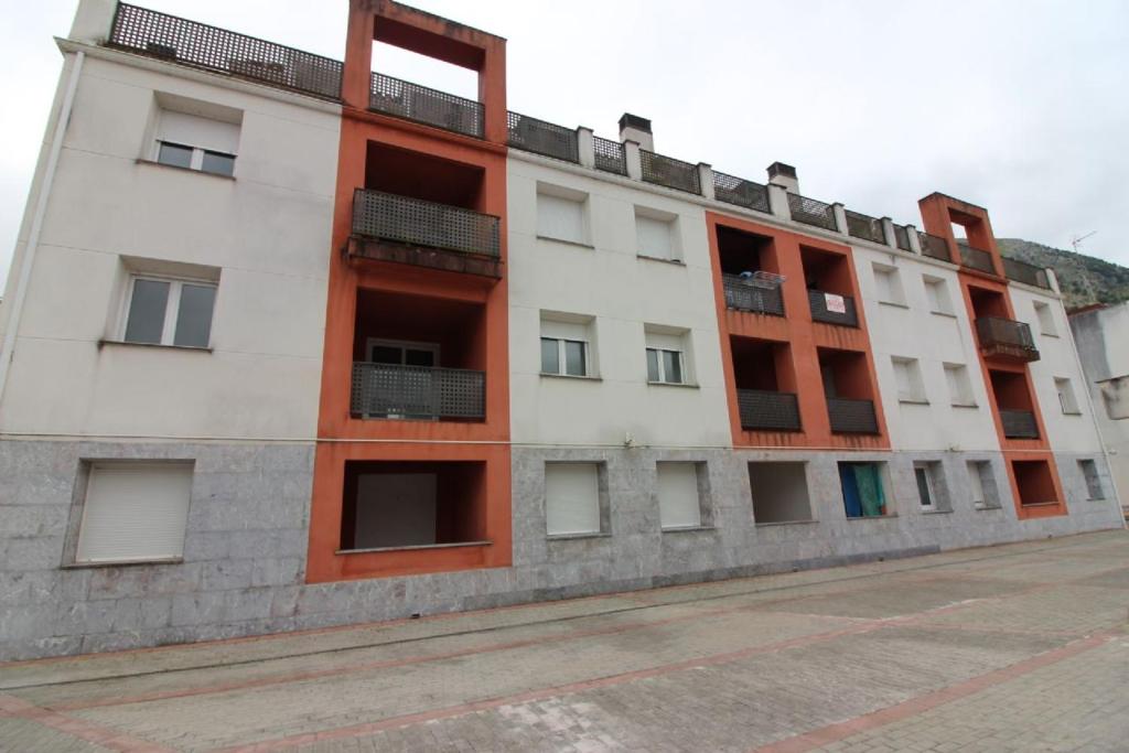 een appartementencomplex met oranje en wit bij La Fuente de la Quintana in Arredondo