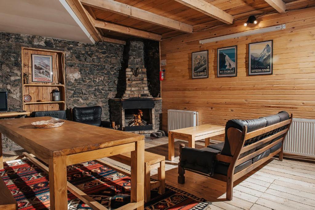 a living room with a table and a fireplace at Kazbegi Hut in Kazbegi