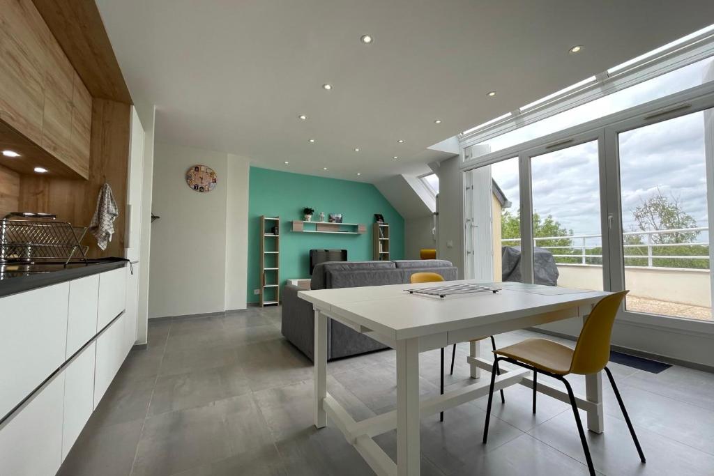 cocina y sala de estar con mesa blanca y sillas en Luxury apartment with exceptional view on the Cher river, en Saint-Avertin