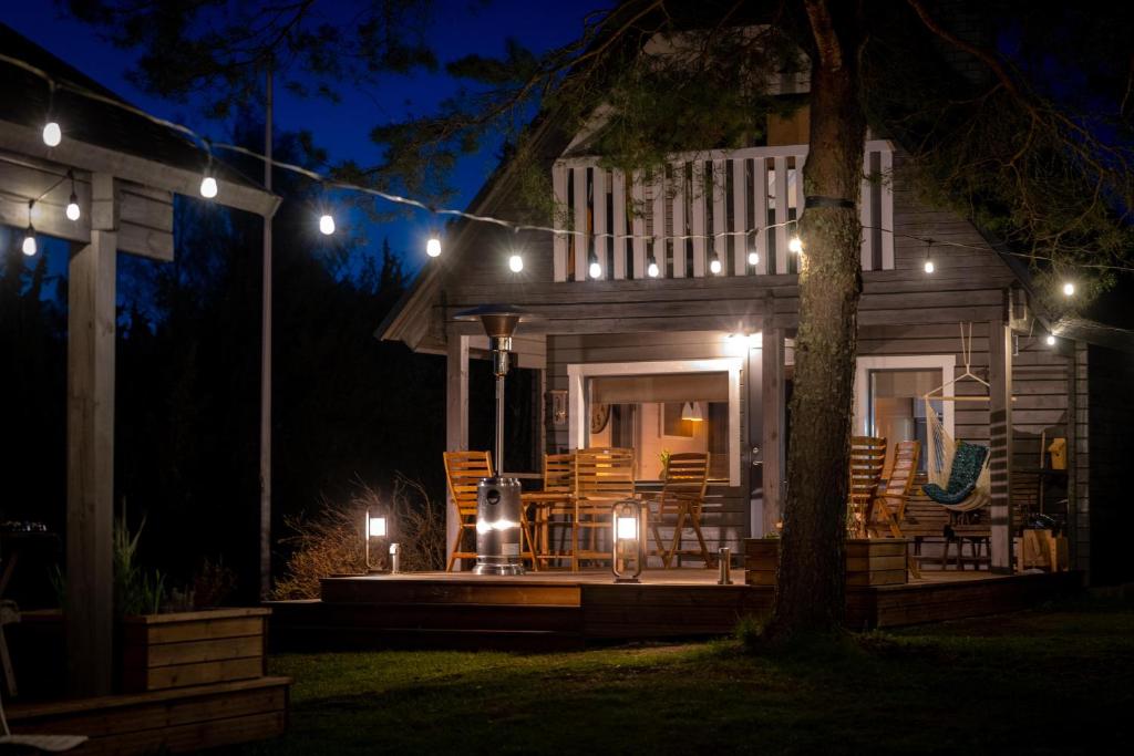 a house with a porch at night with lights at Hiiumaa Summerhouse in Orjaku