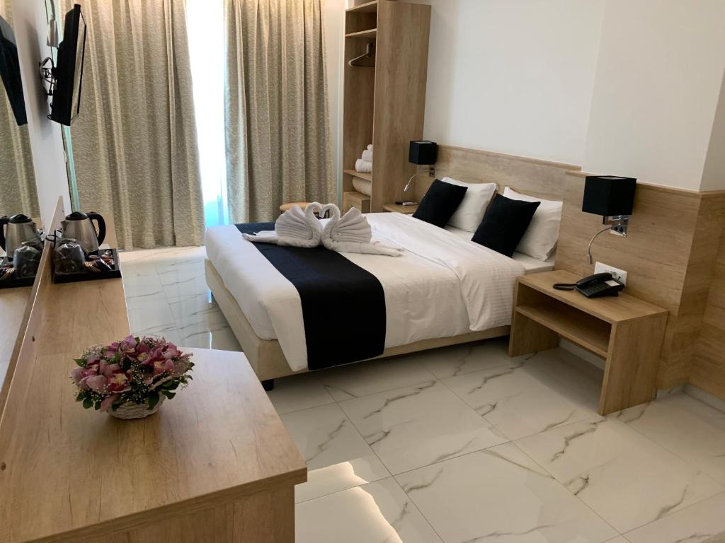 a hotel room with two beds and a desk at Marvel Deluxe Rooms in Heraklio