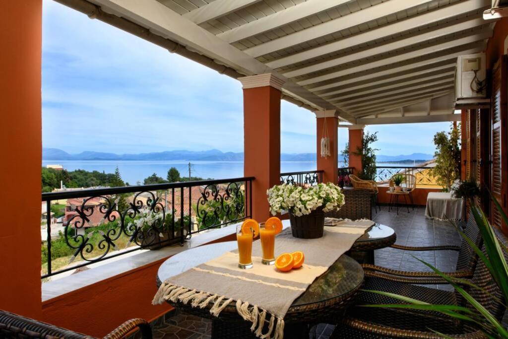 een patio met een tafel en stoelen op een balkon bij Seaview Cottage - Calmare in Petrití