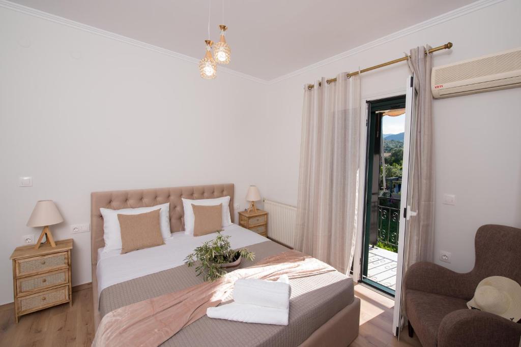 a white bedroom with a bed and a balcony at Liovore Apartments in Lygia