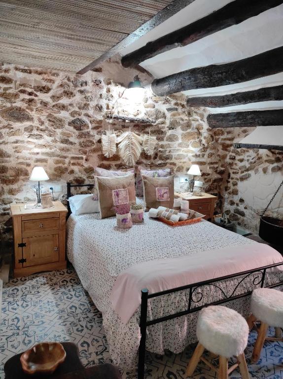 1 dormitorio con 1 cama y 2 mesas y sillas en Casa Rural "El Olivo", en Estercuel