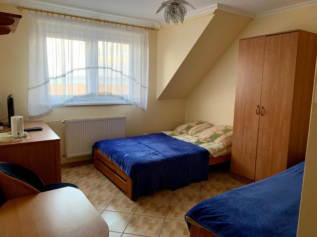 - une petite chambre avec 2 lits et une fenêtre dans l'établissement Pokoje Gościnne ADRIAN, à Krynica Morska