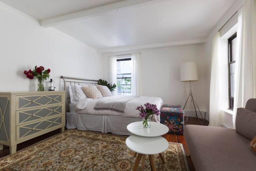 a living room with a bed and a table at Cozy bright studio - Soho/Greenwich Village - 30+Days Only in New York