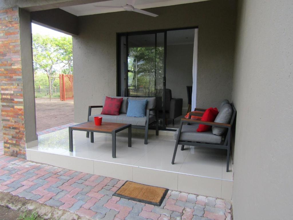 a patio with two chairs and a coffee table at Pafuri Gate Guesthouse in Mabalingwe Game Reserve