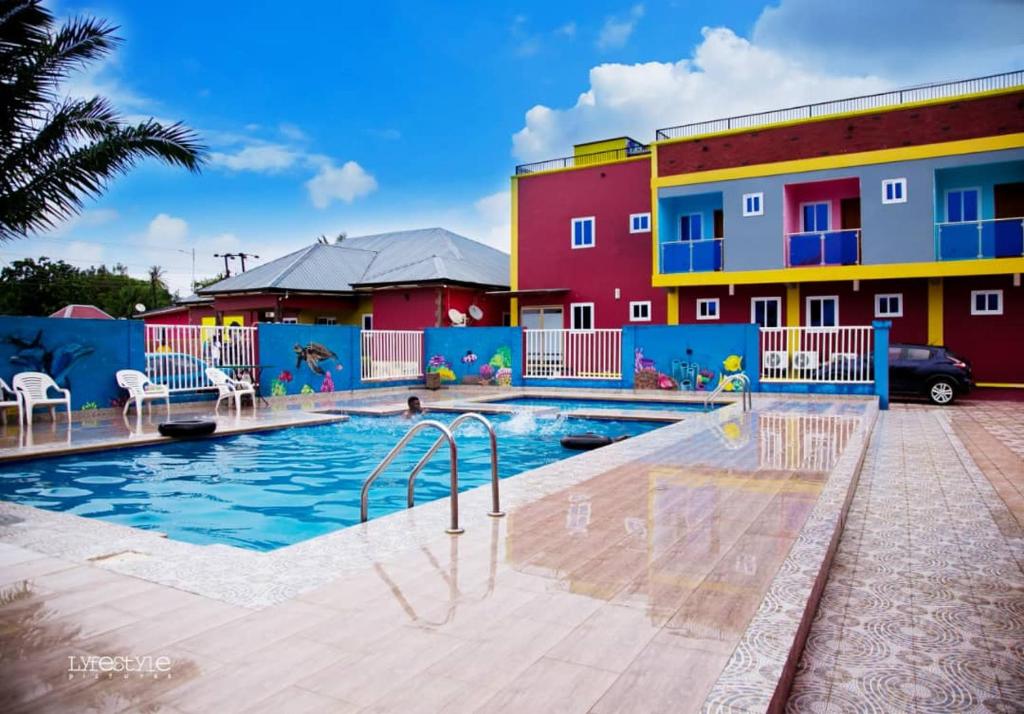a swimming pool in front of a building at Kikis Court Resort in Hohoe