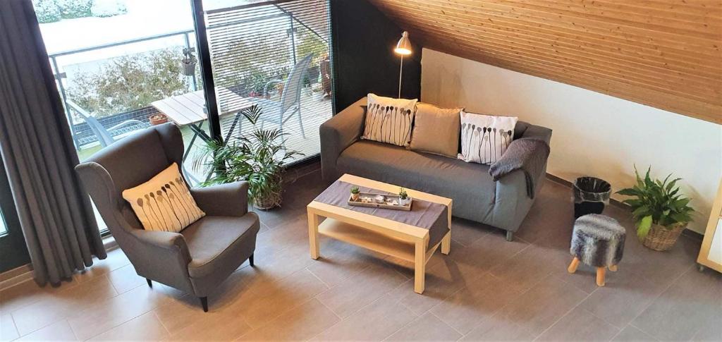 a living room with a couch and chairs and a table at Appartement Lohe in Glüsingerlohe