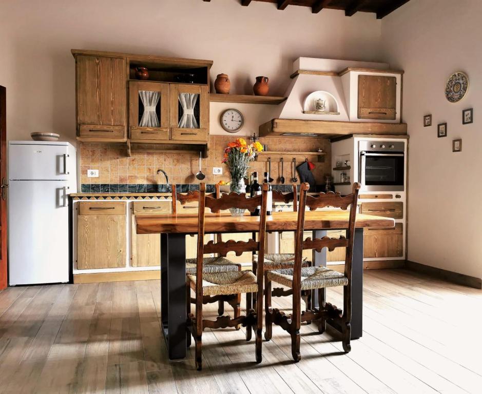 a kitchen with wooden cabinets and a wooden table with chairs at Casa Remo - dolce soggiorno nella Piazza di Greve in Greve in Chianti