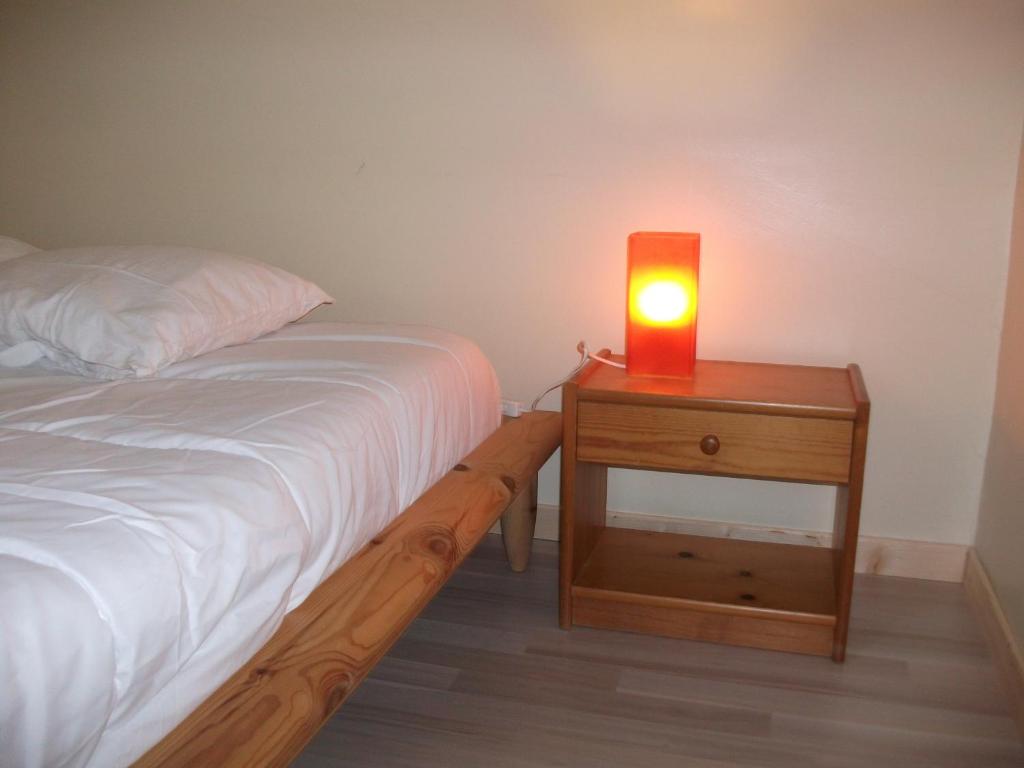 a bed with a light on a nightstand next to a bed sidx sidx sidx at Logement ST GILDAS in Pommerit-Jaudy