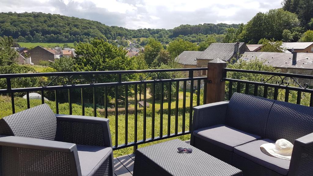 a balcony with a couch and chairs and a view at Le chant des hiboux in Haraucourt