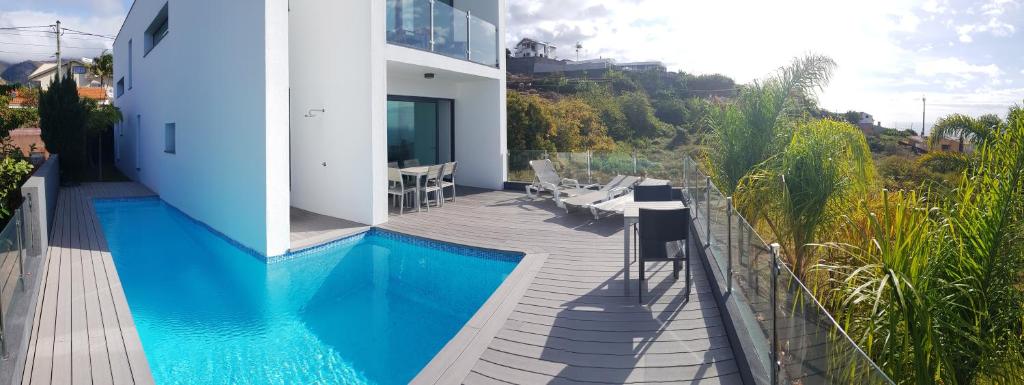 a villa with a swimming pool and a house at Sunshine Villa 150m above Ocean & Sandy Beach in Estreito da Calheta