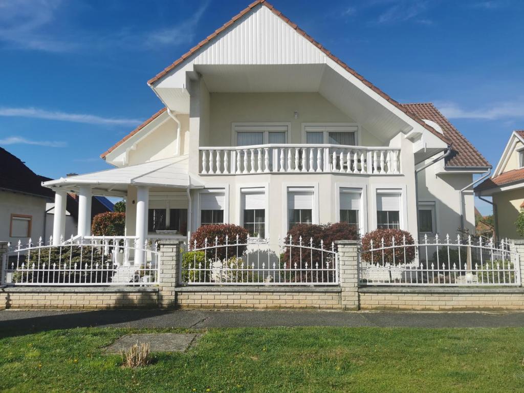 uma casa branca com uma cerca branca em Csabai Vendégház em Bük