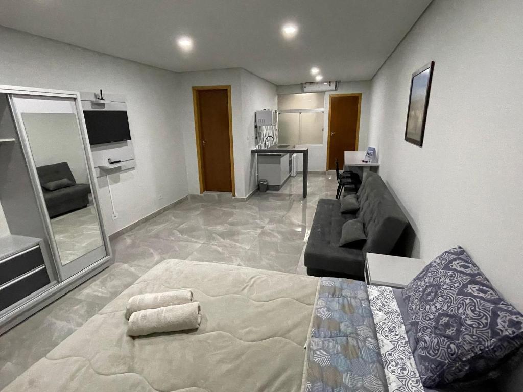 een woonkamer met een bed en een bank bij Novo apartamento Studio a poucos passos do Paraguai - Vila Portes in Foz do Iguaçu