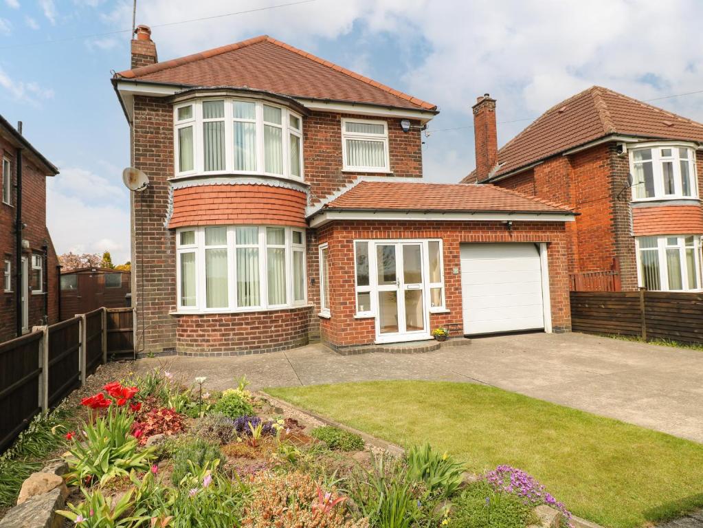 a brick house with a white garage at 75 Mansfield Road in Ault Hucknall