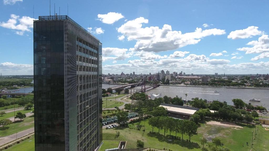 un edificio alto junto a un río y una ciudad en Hotel UNL-ATE, en Santa Fe