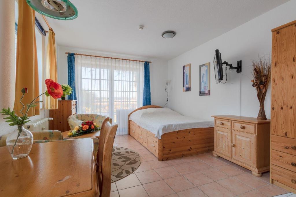 Schlafzimmer mit einem Bett und einem Esstisch in der Unterkunft Ferienwohnung #1 Am Neuensiener See - Seedorf in Sellin