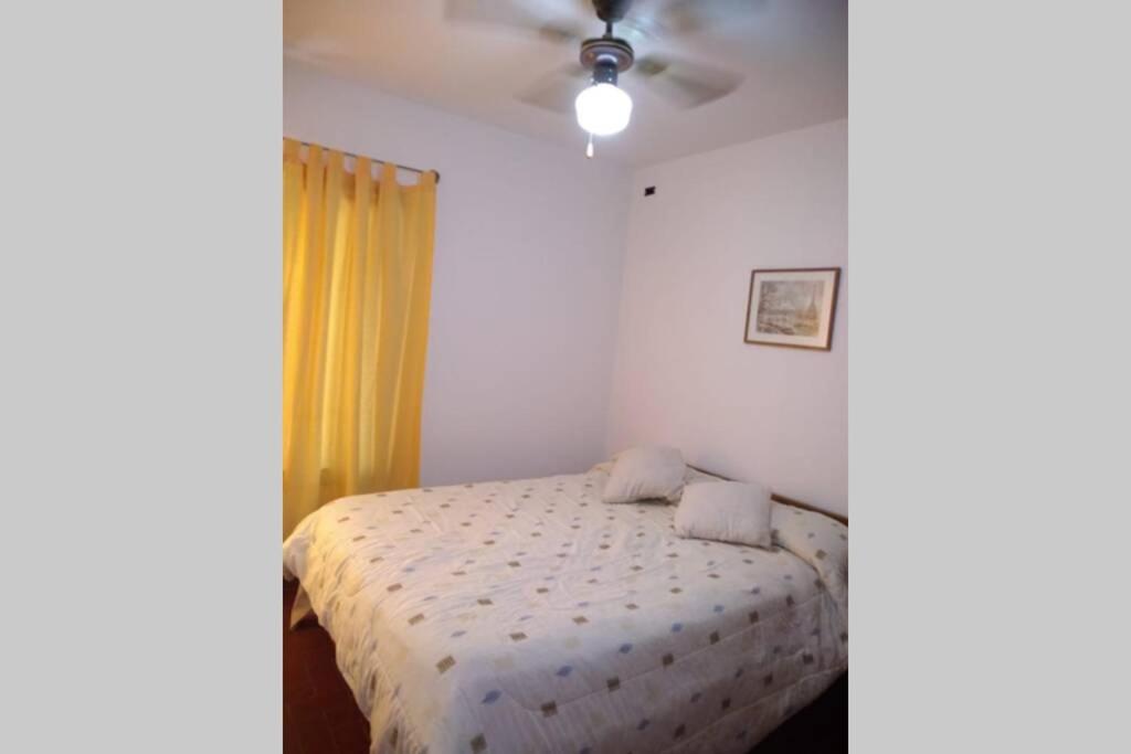 a bedroom with a bed and a ceiling fan at DEPARTAMENTO KRISTINA in Villa Carlos Paz