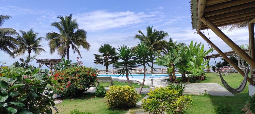 a resort with a swimming pool and palm trees at Caramba Hospedaje in Tonsupa
