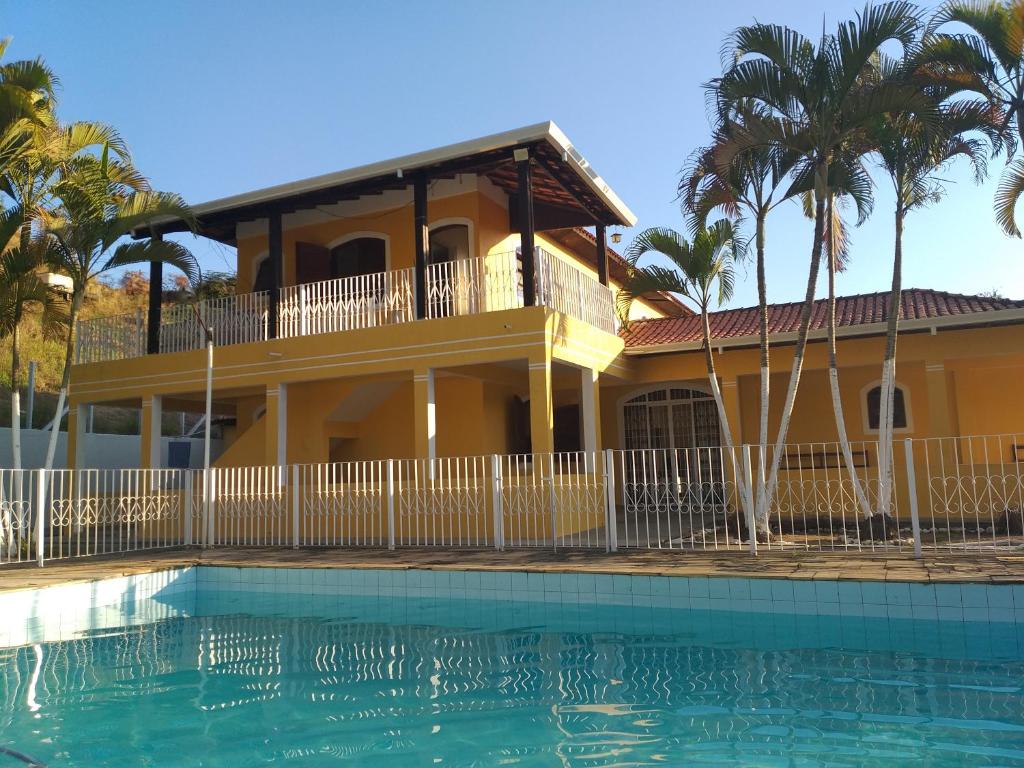 a house with a swimming pool in front of a house at Sitio Recanto da Alegria - MAIRINQUE in Mairinque