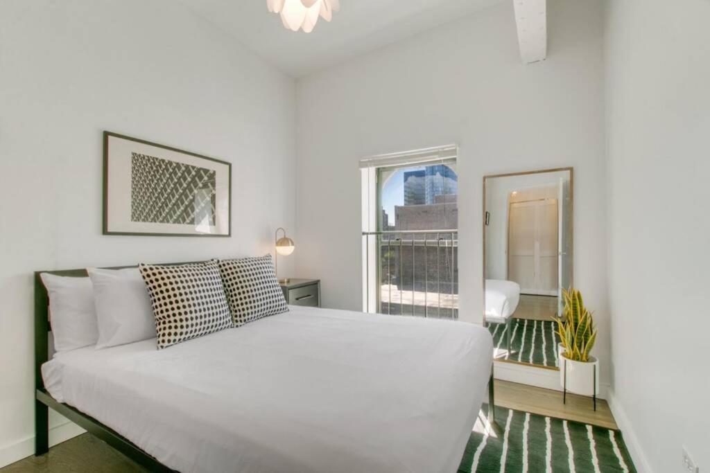 a white bed in a room with a window at West Loop 1BR Apartment with In-Unit Laundry - Lake 301 rep in Chicago