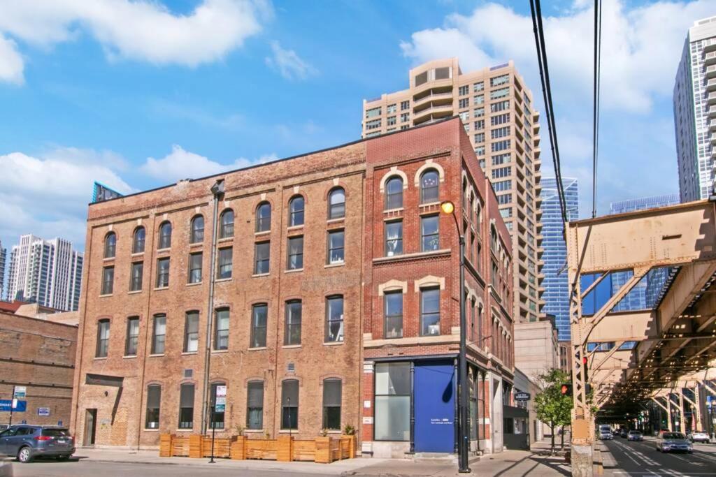 a brick building on a city street with tall buildings at West Loop 1BR Apartment with In-Unit Laundry - Lake 301 rep in Chicago