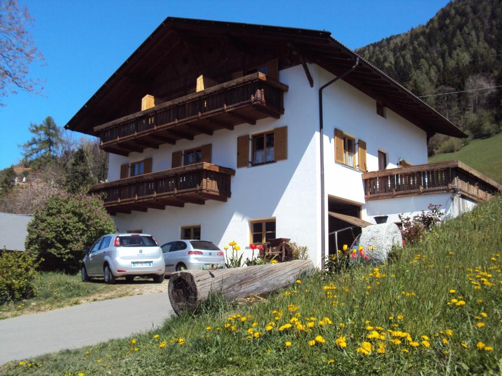 a house with two cars parked in front of it at Aussersalfnerhof in Schenna