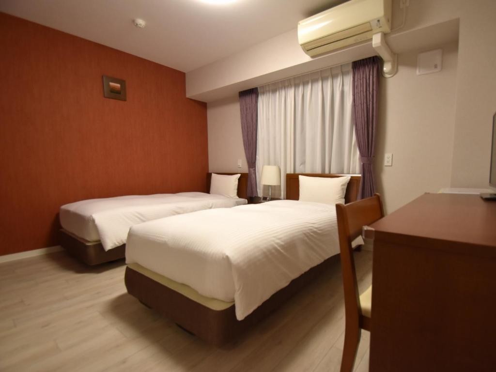 Postel nebo postele na pokoji v ubytování Hotel Hakata Place