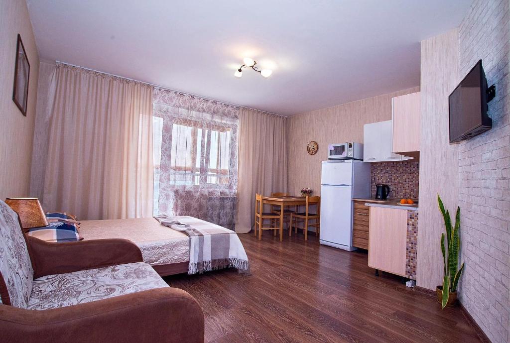 a room with a bed and a kitchen with a table at Studio on Molodogvardeytsev 76, Academ Riverside in Chelyabinsk