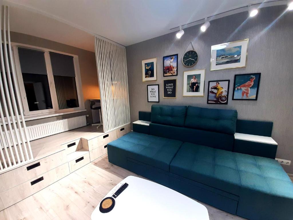 a living room with a blue couch in a room at Relax Point Plus Apartment in Irpin'