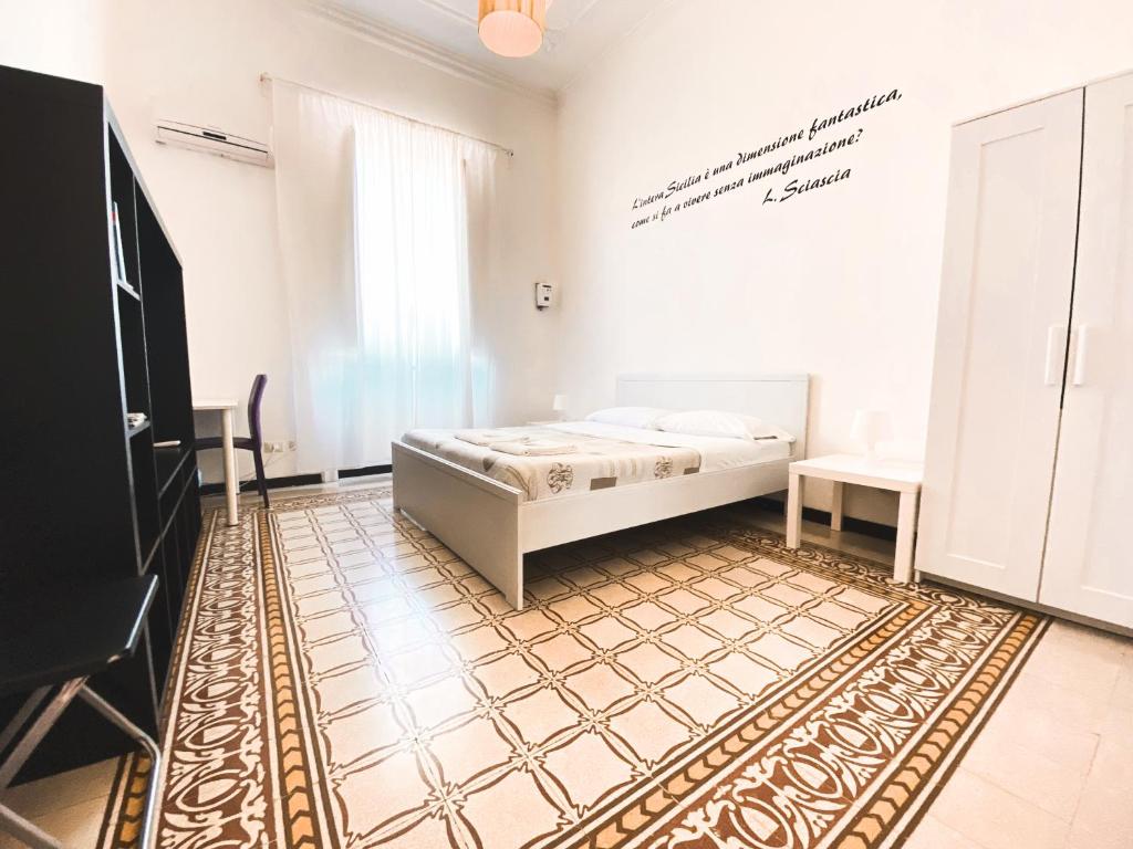 a bedroom with a bed and a rug on the floor at Liolà Palermo in Palermo