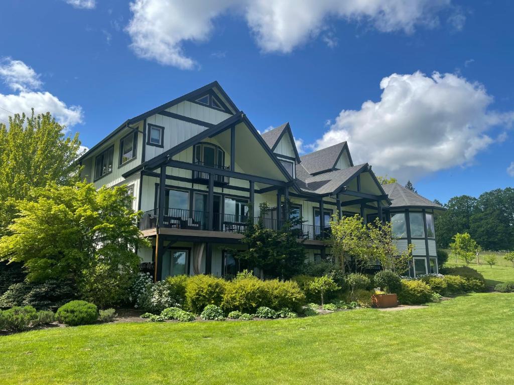 une grande maison avec une grande cour avec de l'herbe dans l'établissement The Setting Inn Willamette Valley, à Newberg