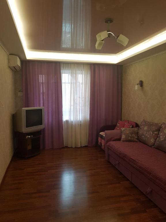 ein Wohnzimmer mit einem Sofa und einem TV in der Unterkunft Квартира в Лузановке2 in Odessa