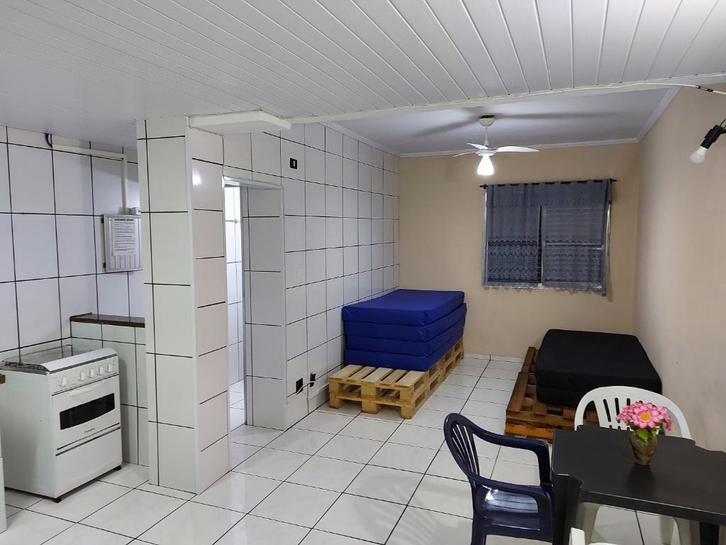 um pequeno quarto com uma mesa e uma cozinha em Apartamento Beira Mar - Vila Guilhermina em São Paulo