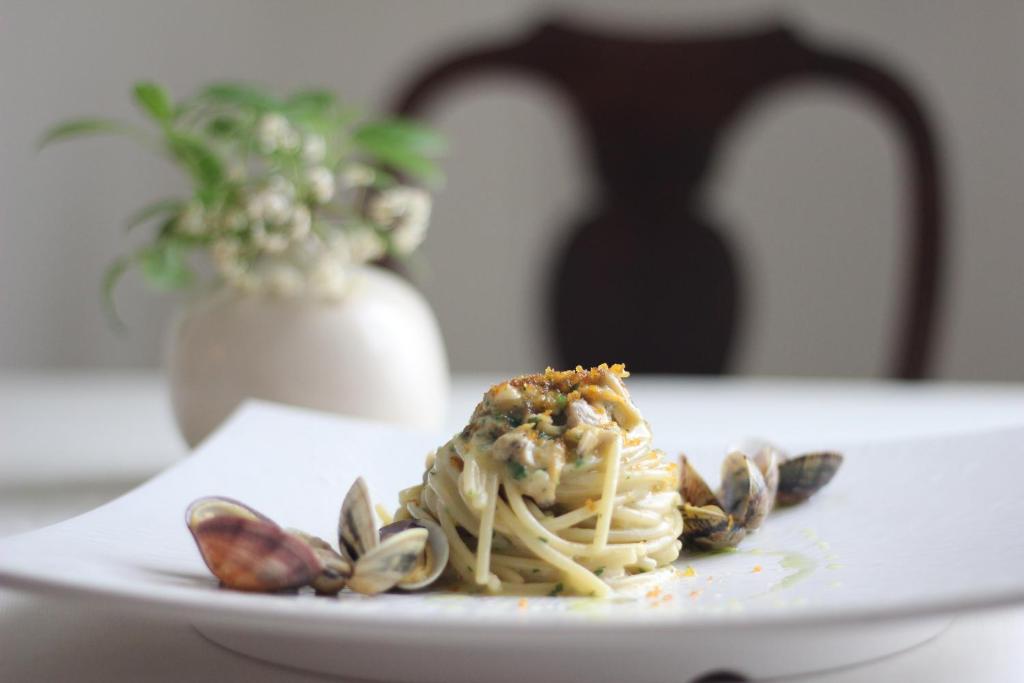 a plate of pasta with nuts on a table at Palace Hotel in Viareggio