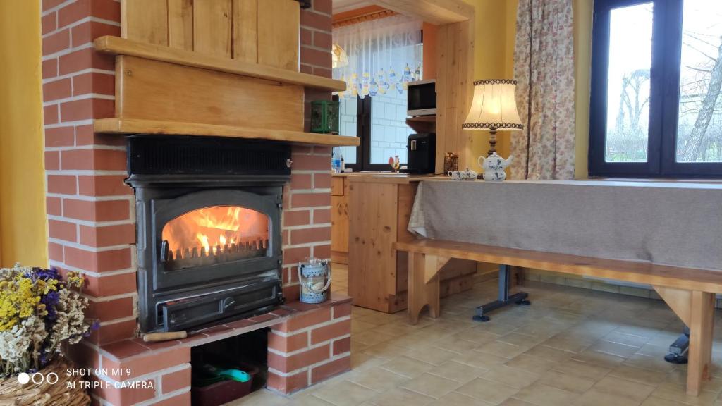 a brick fireplace in a kitchen with a bath tub at Dom mazurski in Zdory