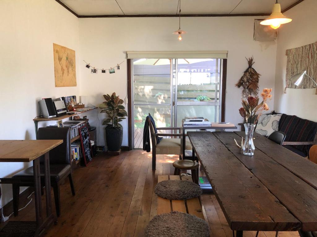 een woonkamer met een houten tafel en een bank bij Hostel Fuji Matsuyama Base in Fujiyoshida