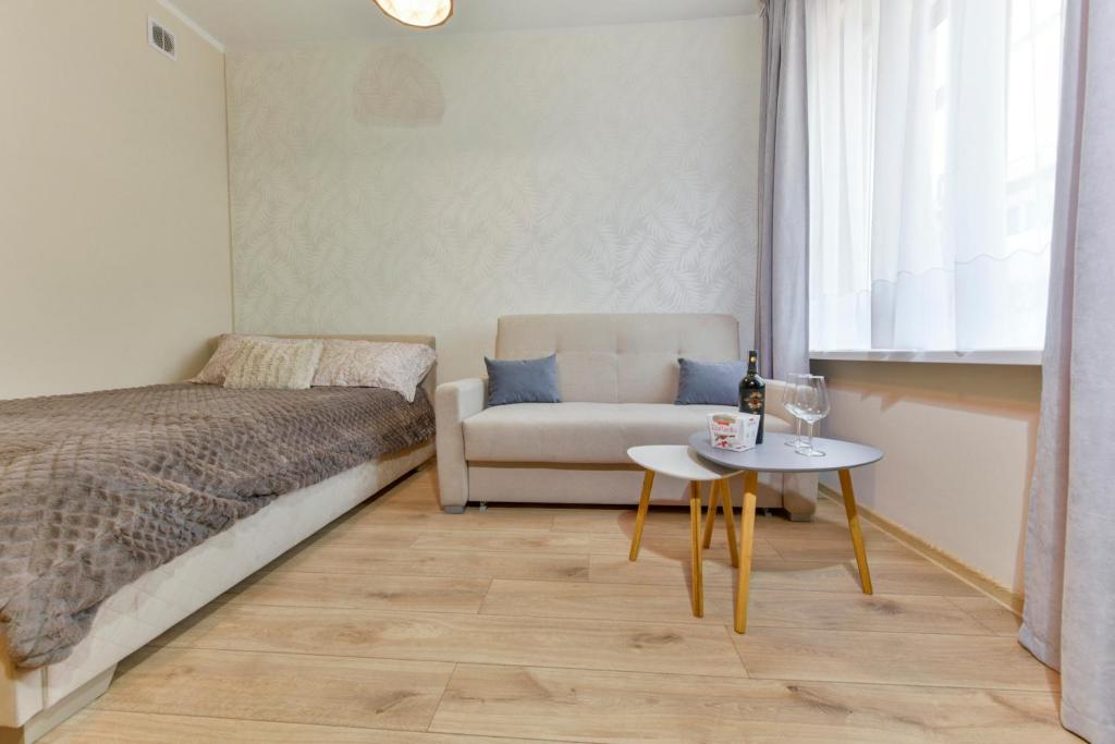 a bedroom with a bed and a table and a chair at Apartament u Ani 2 in Dźwirzyno