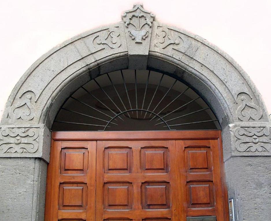 una grande porta in legno con un arco sopra di essa di B&B Il Giglio Bianco a Sorrento