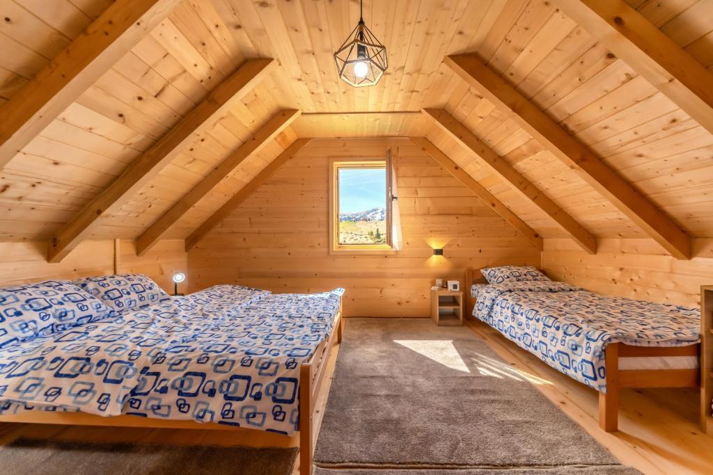 a bedroom with two beds in a wooden house at Green Top in Žabljak