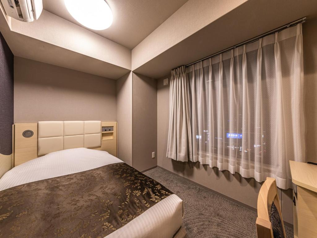 Postel nebo postele na pokoji v ubytování APA Hotel Shin Osaka Eki Tower