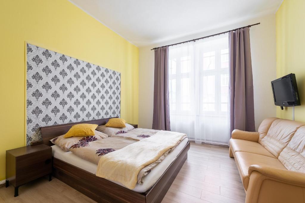 - une chambre avec un lit et un canapé dans l'établissement Spacious Apartment Děčín, à Děčín