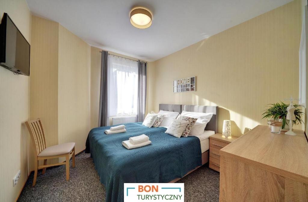 カルパチにあるApartamenty Sun Seasons 24 - Karpacz Centrumのベッドルーム(青いシーツとテレビ付)