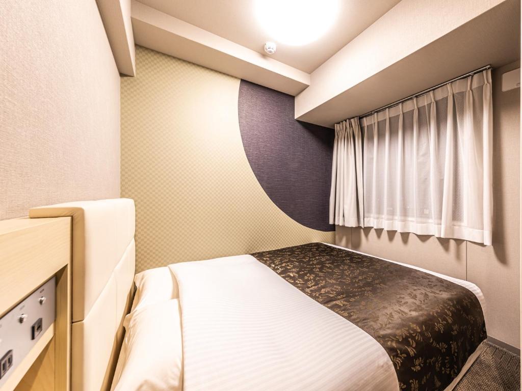 Postel nebo postele na pokoji v ubytování APA Hotel Shin Osaka Eki Tower