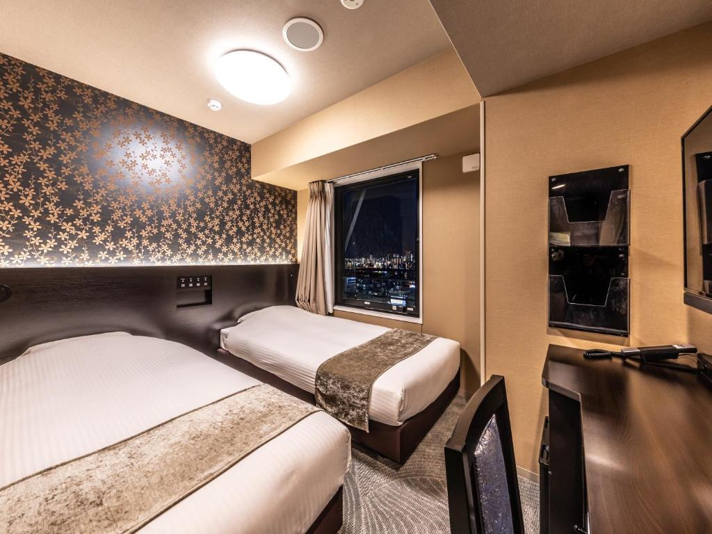 Postel nebo postele na pokoji v ubytování APA Hotel Shin Osaka Eki Tower