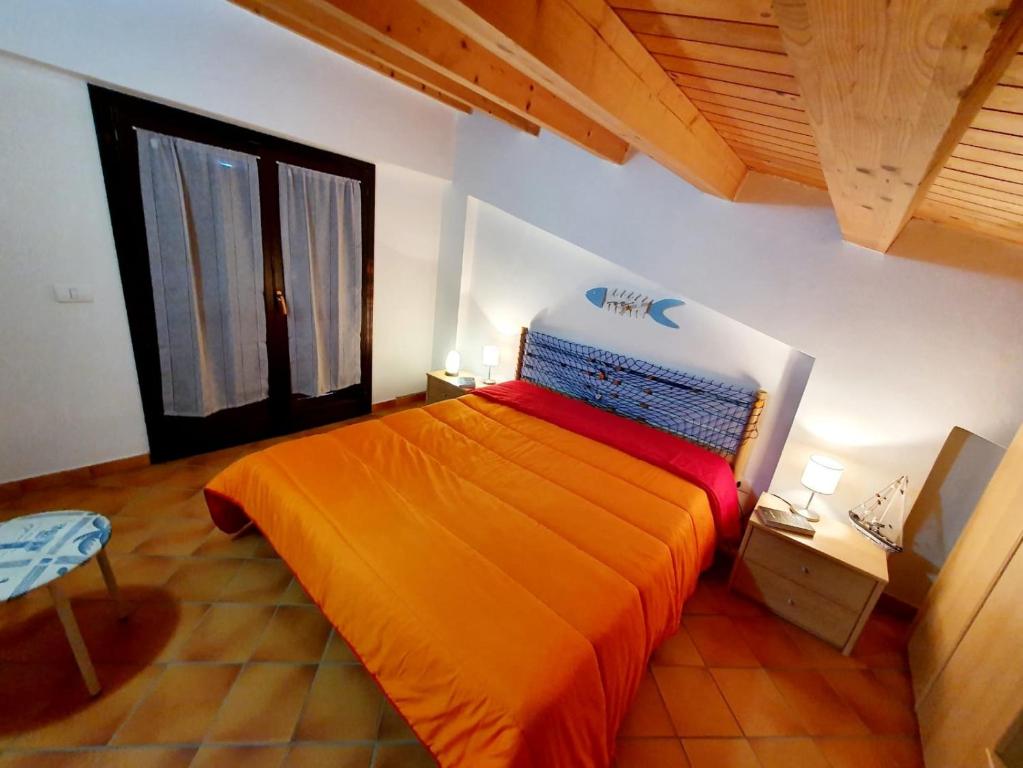 um quarto com uma cama grande e uma colcha laranja em Casa I Sogni In Terrazzo em Marzamemi