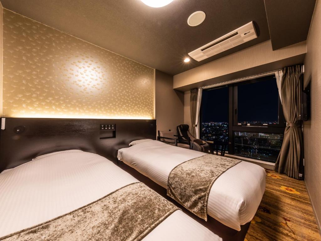 Postel nebo postele na pokoji v ubytování APA Hotel Shin Osaka Eki Tower