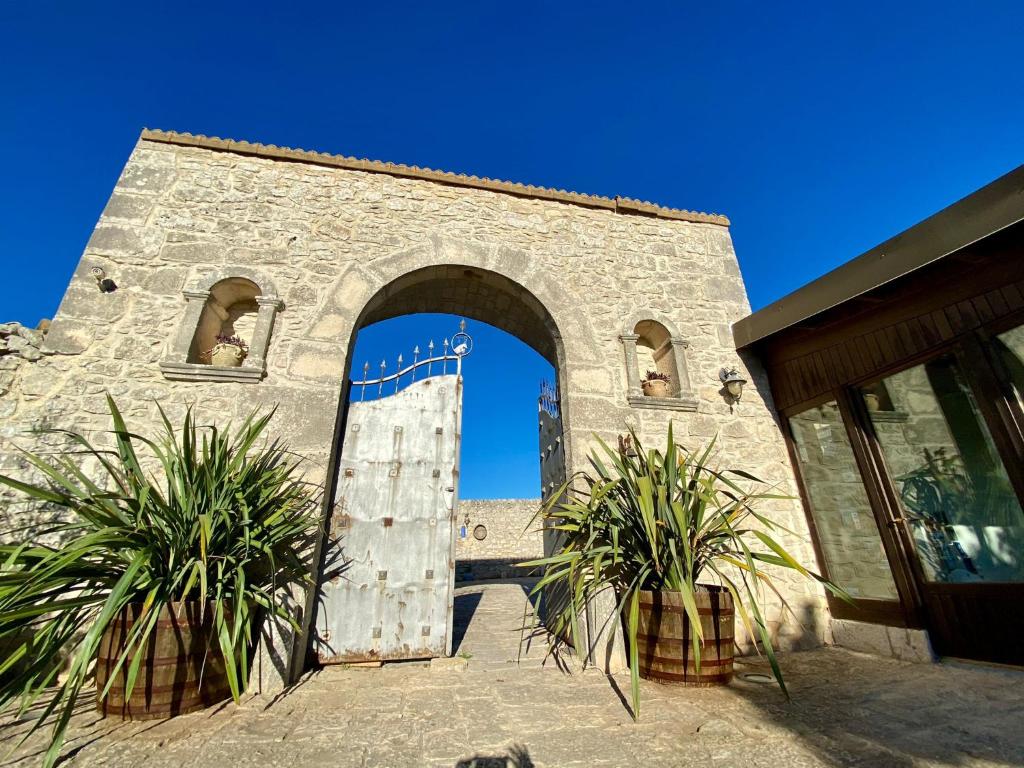 un ingresso a un edificio con porta in legno di Mastro Vanni - Urban Masseria a Ragusa